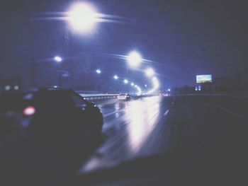 Cars on illuminated road in city at night