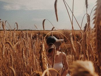 Person in wheat field against sky