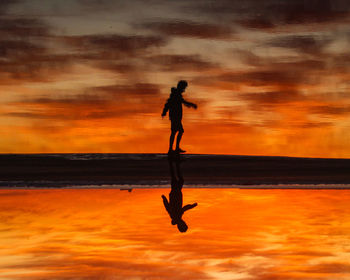 Silhouette man jumping against sky during sunset