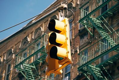 Low angle view of road signal against buildings in city