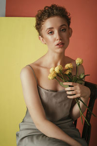 Portrait of a woman holding red flower