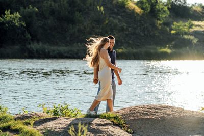 Declarations of love, candid couple in love holding hands on nature background.