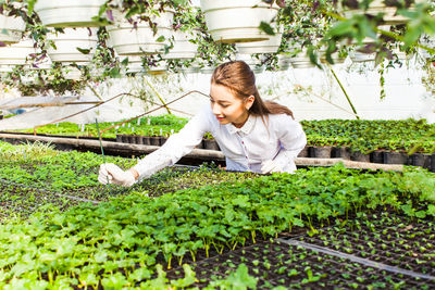 Young woman standing in greenhouse