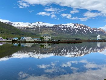 Scenic view of lake by snowcapped mountains against sky