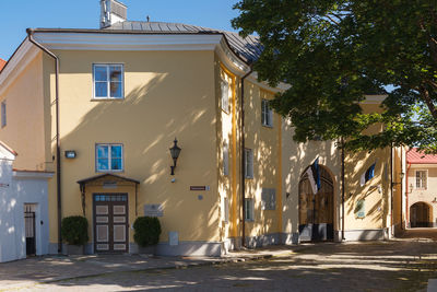 Residential building by road against sky