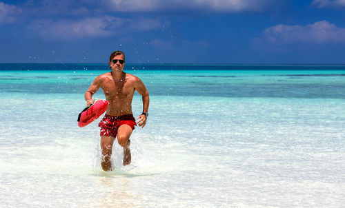 Portrait of young man standing at beach