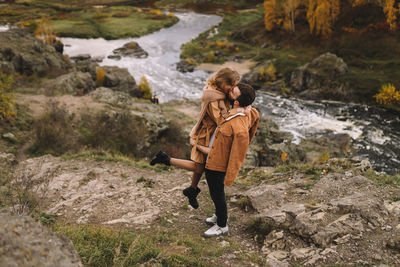 Happy people in love are travel hike in nature in the autumn forest. romantic trip to countryside