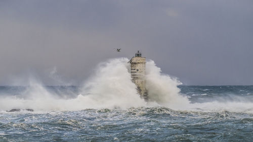 Water splashing in sea against clear sky