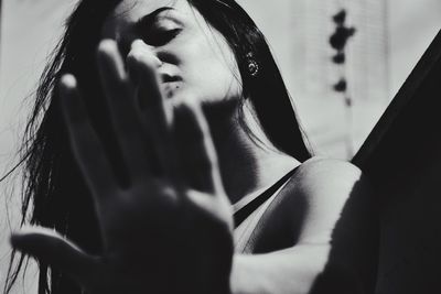 Low angle view of young woman showing stop gesture