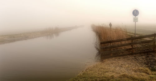 Scenic view of lake against sky during foggy weather