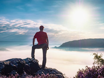 Man stay on rock of trek summit. peak in saxon switzerland national park and photographs the sunrise