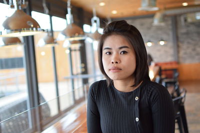 Portrait of beautiful young woman sitting in cafe