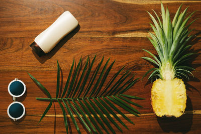 Different items for beach vacations. sunscreen, sunglasses and pineapple fruit