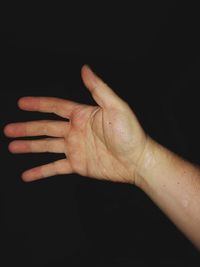 Close-up of woman hand over black background