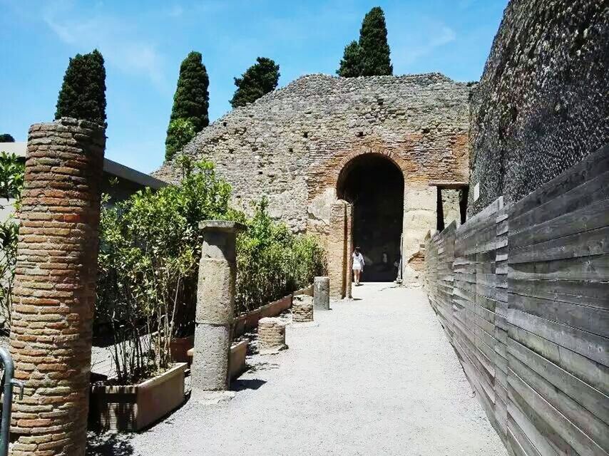 architecture, built structure, building exterior, arch, history, the way forward, stone wall, sky, old, the past, sunlight, diminishing perspective, day, no people, old ruin, wall - building feature, blue, leading, outdoors, low angle view