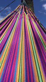 Low angle view of multi colored flags hanging against sky