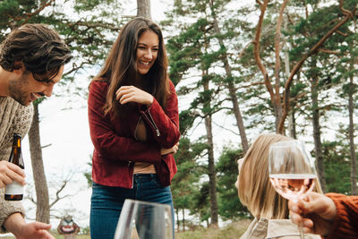 Cheerful woman talking with friends enjoying drinks in back yard