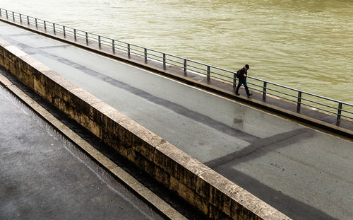 High angle view of men standing on railing by sea