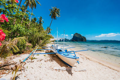 Boat moored at beach against sky