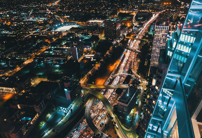 High angle view of illuminated street amidst buildings in city at night