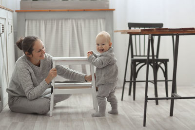 Side view of boy playing with toy on floor at home