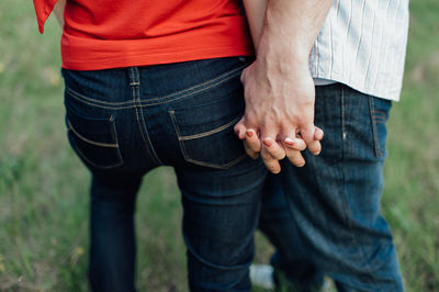 Midsection of couple holding hands