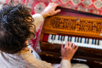 Rear view of woman playing piano