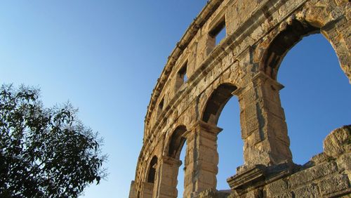 Low angle view of old ruin against clear blue sky