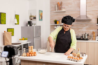 Side view of woman preparing food at home