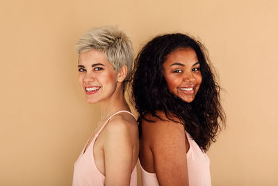 Portrait of smiling young woman against gray background