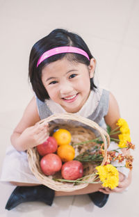 Portrait of a smiling girl holding fruits