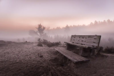 Empty bench in park during winter