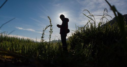 Side view of silhouette man standing on field against sky