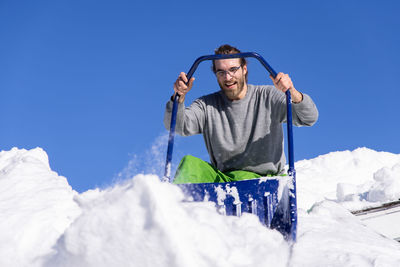 Man with umbrella against sky during winter