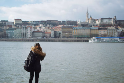 Rear view of woman on river against sky