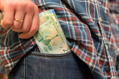 Midsection of man removing paper currency from pocket