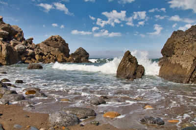 Rocks on beach against sky