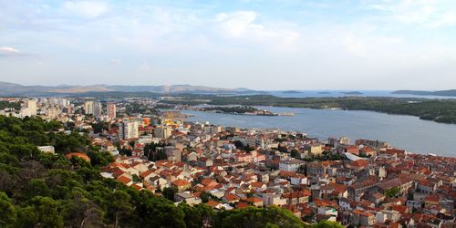 High angle view of townscape by sea against sky