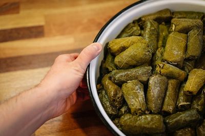 High angle view of person preparing dolmades on table