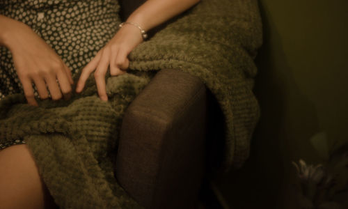 Midsection of woman sitting in park