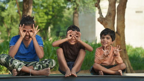 Funny kids doing yoga pose in the park outdoor. healthy life style concept.