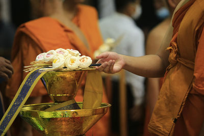 Monk placing a cremation flower on the tray to pray for dead people.