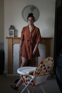 Portrait of woman sitting on seat at home