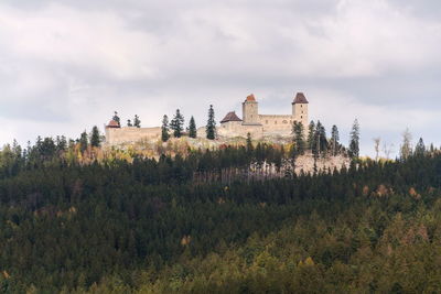 Plants and buildings on field against sky