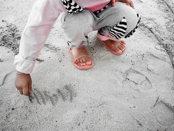 Low section of person crouching at beach