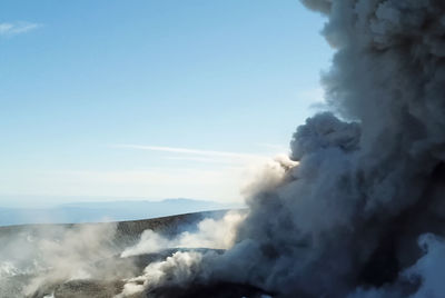 Smoke emitting from volcanic mountain against sky