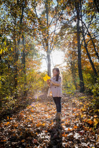 Rear view of woman standing in forest