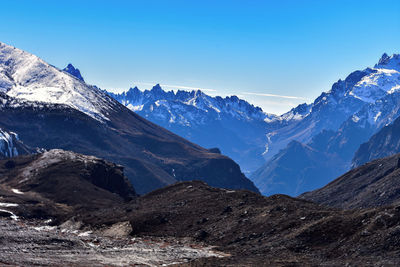 Scenic view of snowcapped mountains against blue sky