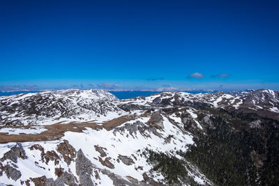 Scenic view of snowcapped mountains against clear blue sky