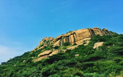 Low angle view of rock formations against blue sky